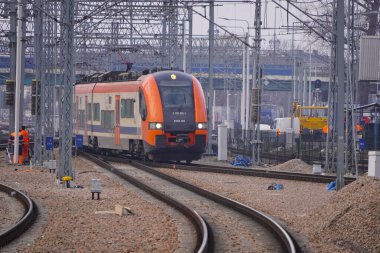 Tren istasyonundaki turuncu ve mavi elektrikli tren. Parça