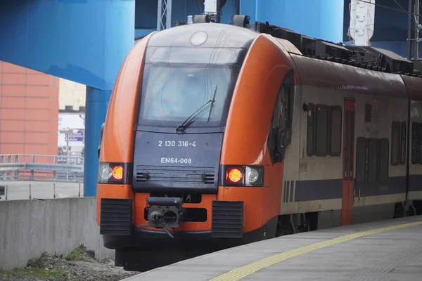 Kereta listrik oranye dan biru di stasiun kereta api. Lacak — Stok Foto