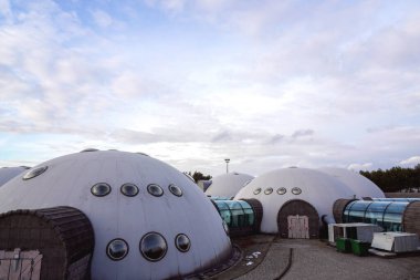 Yuvarlak pencereli ve şeffaf geçitli yarı dairesel binalar. Gezegen sergisi kompleksi veya eğitim parkı istisnai bir yer.