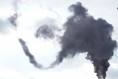 Mavi gökyüzüne karşı yükselen siyah duman. Endüstriyel şehir. sorun zararlı emisyonlar ve merkezi ısınma, eko ve küresel ısınma hava kirliliği