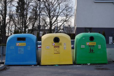 Krakow, Polonya 12.24.2019: farklı renk çöp kutuları ayrı çöp toplama ve daha ileri işleme için. Çöp tanklarına saçılmış. Yere çöp bırak. Çöpü ayır