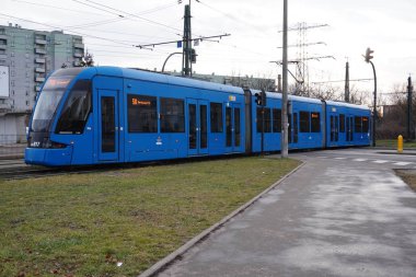 Poland, Krakow 02.18.2020: City blue tram Bombardier NGT8 on the city street. Eco-friendly urban public transport. urban forestry, protection of the environment