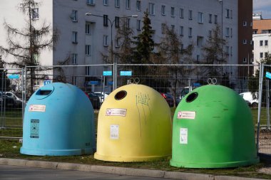 Krakow, Poland 10.03.2020: garbage bins of different colors for separate collection of garbage and further processing. scattered garbage at tanks. Leave garbage on the ground. Segregate trash
