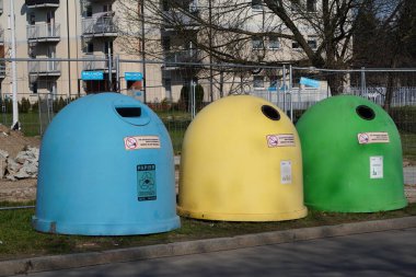 Krakow, Poland 10.03.2020: garbage bins of different colors for separate collection of garbage and further processing. scattered garbage at tanks. Leave garbage on the ground. Segregate trash