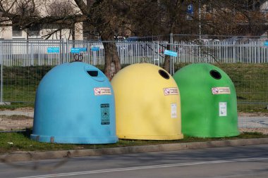 Krakow, Poland 10.03.2020: garbage bins of different colors for separate collection of garbage and further processing. scattered garbage at tanks. Leave garbage on the ground. Segregate trash
