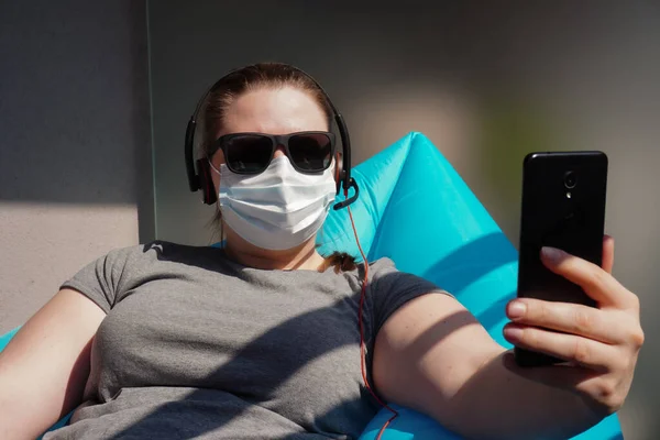 Europäische Bloggerin Mit Dunkler Brille Medizinischer Maske Kopfhörer Telefon Arbeitet — Stockfoto