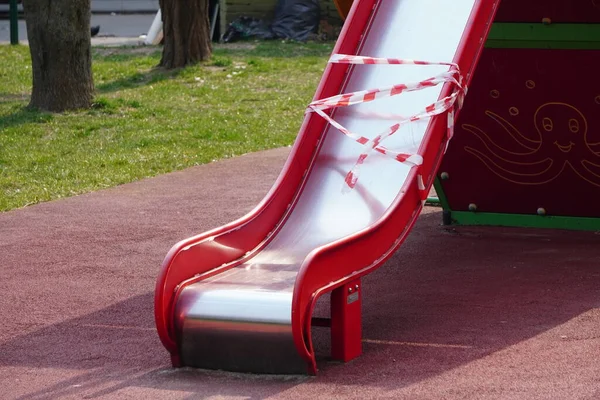Kapalı alanda çocuklar için bir atlıkarınca ve salıncaklar. Çocuk parkına da gidemeyiz. Koronavirüsü önleme. Virüse karşı mücadele. Bahçedeki çocuk parkında hiç çocuk yok..