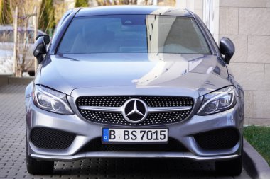 Krakow, Polonya 19.02.2020: Yeni lüks Mercedes-benz C-sınıfı gri renkli, otoparkın yanındaki park yeri. Arabanın ön görüntüsünü detaylandır.