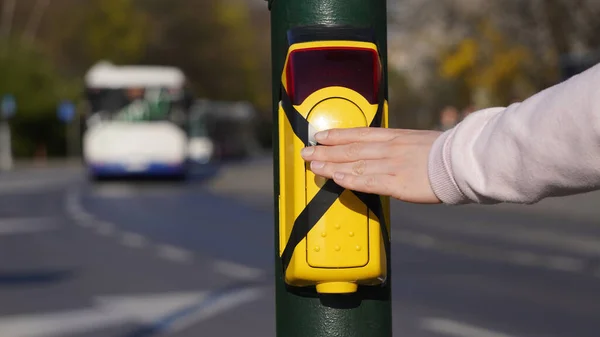 Turned off traffic light button for crossing the roadway with hand. Crossed pedestrian yellow push button during coronavirus pandemic in Poland, Krakow.Safety of people, not allowed to touch buttons.