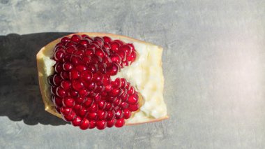 Bol tohumlu Nar Meyvesi Barışı, gri arka planda kırmızı egzotik bir meyve. Doğranmış nar. Nar tohumları yemek için hazır.