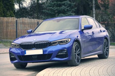 Krakow, Polonya 22.03.2020: Mavi araba BMW 3 G20 lüks Alman sedanı, şehir parkına park ediyor. Arabaların ön görüntüsünü detaylandır. Bir yerleşim bölgesindeki kaldırıma yasa dışı park edilmiş bir araba. Trafik ihlalleri
