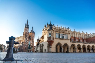 Krakow, Polonya 20.04.2020: boş, şehir merkezindeki ana pazar meydanı şafak vakti mavi bulutsuz bahar gökyüzüne karşı. Turist yok, kapalı restoranlar ve dükkanlar yok. Kapalı durum sınırları
