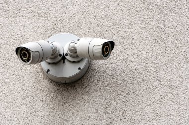 Sokaktaki modern bir ofis binasının ön cephesinde iki kamera, şehirdeki güvenlik. Olanlara karşı gizli çekim. modern teknolojiler ve ekipmanlar.