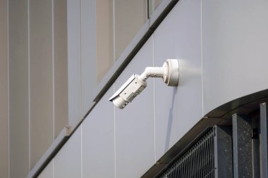 Caddedeki modern bir ofis binasının ön cephesinde güvenlik kamerası var. Olanlara karşı gizli çekim. modern teknolojiler ve ekipmanlar.