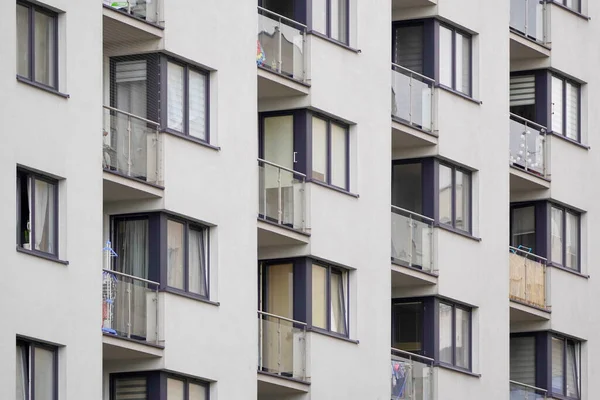 glass balconies of multi-storey building made of concrete. housing for people in a big city. French glazing of an apartment complex.