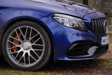 Krakow, Polonya 19.02.2020: New lüks spor araba Mercedes-benz C-sınıfı C63 AMG W205 mavi renk, şehir parkına park. Ön görünüm arabalarını detaylandır.