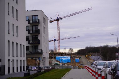 İnşaat vinci, tamamlanmamış çerçeve ve mavi gökyüzüne karşı tuğla ev. Turna ve inşaat işi. Büyük sarı makine vinç. İnşaat konsepti. Ağır şeyleri kaldırmak