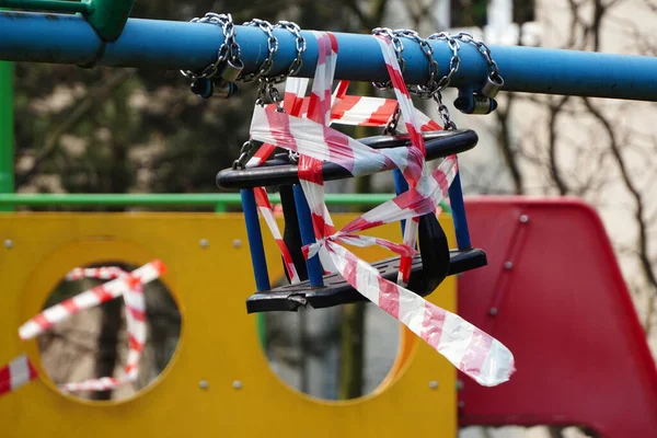 Kapalı alanda çocuklar için bir atlıkarınca ve salıncaklar. Çocuk parkına da gidemeyiz. Koronavirüsü önleme. Virüse karşı mücadele. Bahçedeki çocuk parkında hiç çocuk yok..