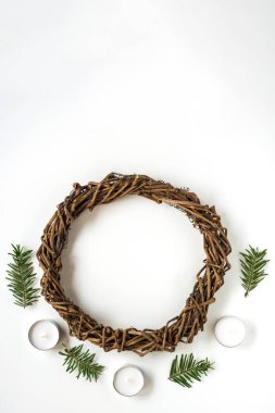 Beyaz arka planda Noel çelengi ya da Paskalya için yuva, mumlar ve ladin dalları. Yaratıcılıkla el işi, çocuklarla dikiş işi. DIY, tatil dekorasyonu. Kopyalama alanı ile düz
