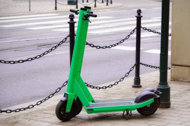 Pavers Krakow, Polonya, Avrupa üzerinde iki yeşil scooter duruyor. Şehir elektrikli scooter kiralama. Yetişkinler ve çocuklar için çevre dostu bireysel ulaşım ve eğlence.