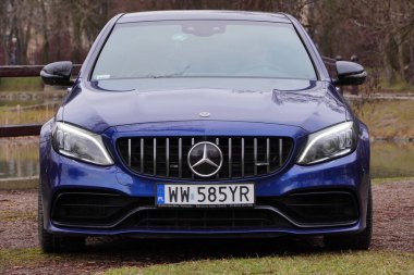 Krakow, Polonya 19.02.2020: New lüks spor araba Mercedes-benz C-sınıfı C63 AMG W205 mavi renk, şehir parkına park. Ön görünüm arabalarını detaylandır.