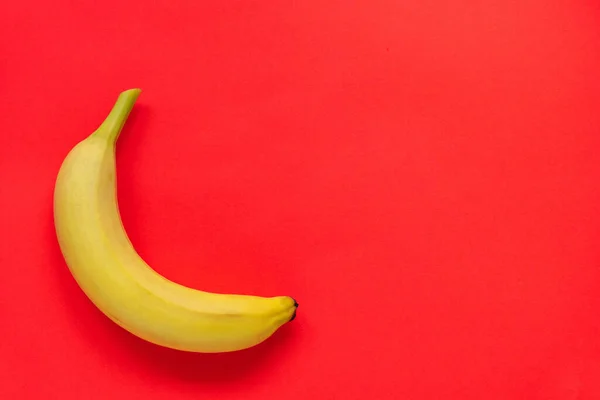 Jeden Żółty Dojrzały Banan Czerwonym Tle Tropikalny Owoc Zdrowe Wegetariańskie — Zdjęcie stockowe