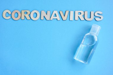 Antiseptik, yazıt koronavirüsü mavi arka planda duran ahşap harflerden oluşur. Copyspace ile bir boşluk. Düz karantina konsepti, Covid19, bakteri.