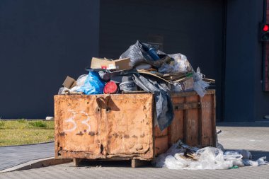 İnşaat konteynırında büyük miktarlarda çöp karıştırılmış. Sıralama, sıfır atık. İkinci el boşluk. Karışık malzeme arkaplanı Krakow, Polonya 05.01.2019 geri dönüşümü