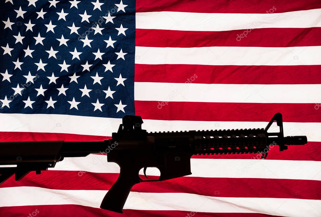 AR-15 carbine rifle silhouette and American stars & stripes flag background