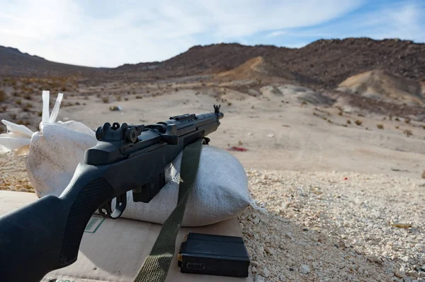 砂漠の風景を見下ろすサンドバッグの上に眠るライフル — ストック写真