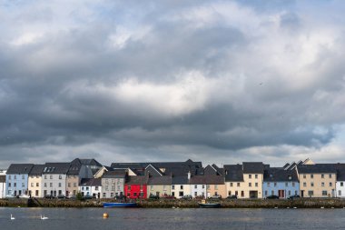Galway şehrinin Claddagh bölgesinin panoramik manzarası, bulutlu dramatik gökyüzü.