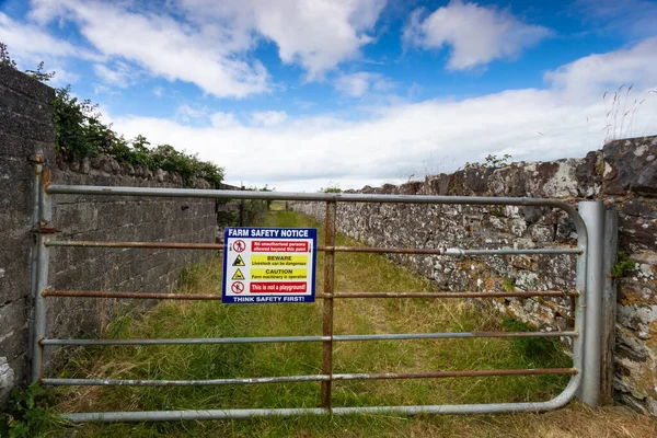 アイルランド共和国の農村部の農業ゲート入り口のゲート上の農場安全通知サイン — ストック写真