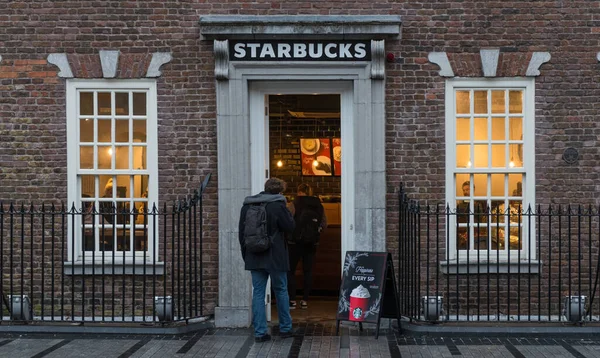 アイルランドのコルクシティ 12月2016 男はコルク市中心部のEmmet Placeにスターバックスのコーヒーハウスに入る ロイヤリティフリーのストック画像