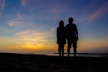 Gün batımında aşık bir çiftin silueti.