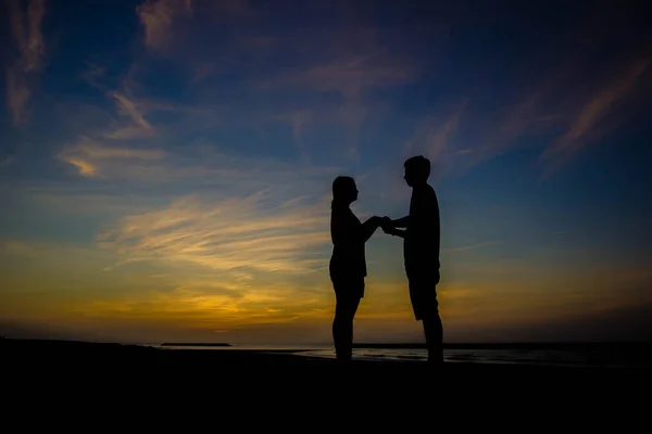 Silhuett av ett par kär vid solnedgången — Stockfoto