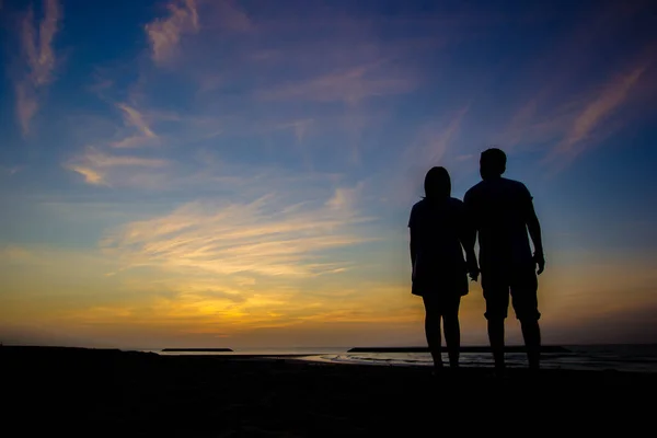 Silhueta de um casal apaixonado ao pôr do sol — Fotografia de Stock