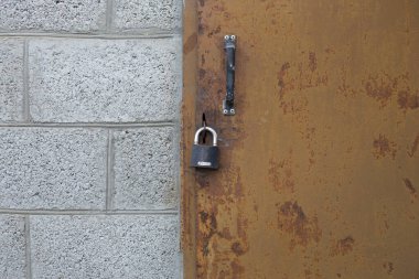 Kapıdaki demir kilit ve beton duvar.