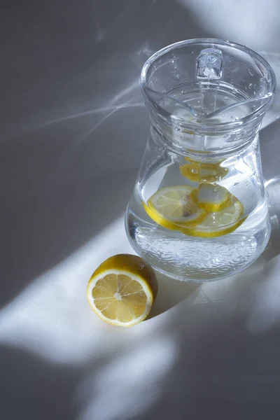 Carafe of water with lemon and half a lemon