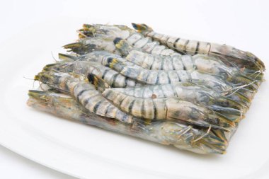 Donmuş taze karidesler beyaz arka planda pişen deniz ürünleri için hazırlanıyor.