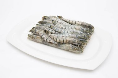 Donmuş taze karidesler beyaz arka planda pişen deniz ürünleri için hazırlanıyor.