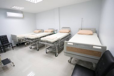 Yatağı ve hastane teçhizatı olan bir dinlenme odası. Beyaz kumaşlı yatak.