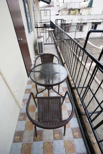 The two deck chairs and a small table in the balcony with a view