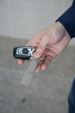 Kablosuz uzaktan kumandalı araba anahtarı ve beyaz arka planda deri zincir.