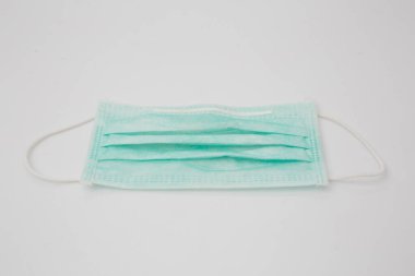 Koronavirüse karşı korunmak için antiviral tıbbi maske. Cerrahi koruyucu maske. Beyaz arka planda tıbbi solunum bandajı var. Virüs ve salgın COVID-19 'un yayılmasının önlenmesi.