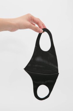 Siyah tek kullanımlık tıbbi maske beyazda izole edilmiş.