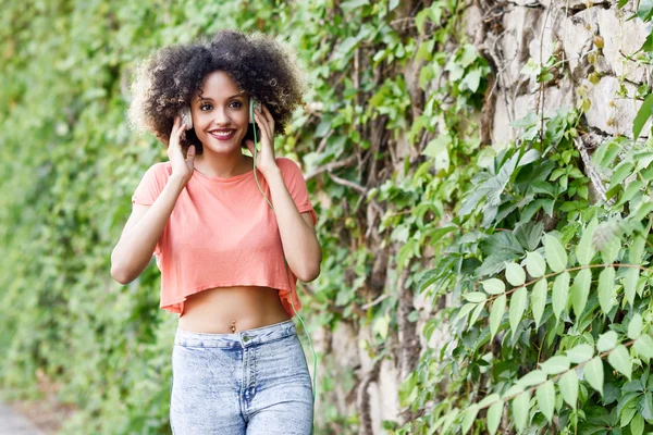 Genç kadın kentsel parkta gülümseyen afro saç modeli ile siyah — Stok fotoğraf