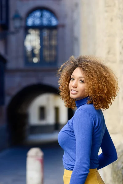 Chica joven con peinado afro en el fondo urbano — Foto de Stock