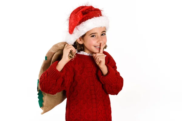 Очаровательная маленькая девочка в шляпе Санты с подарочной сумкой. — стоковое фото