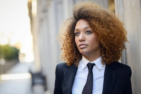Femme d'affaires noire portant costume et cravate en arrière-plan urbain — Photo