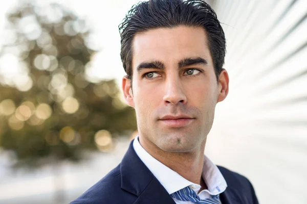 Young businessman wearing blue suit and tie in urban background — Stock Photo, Image